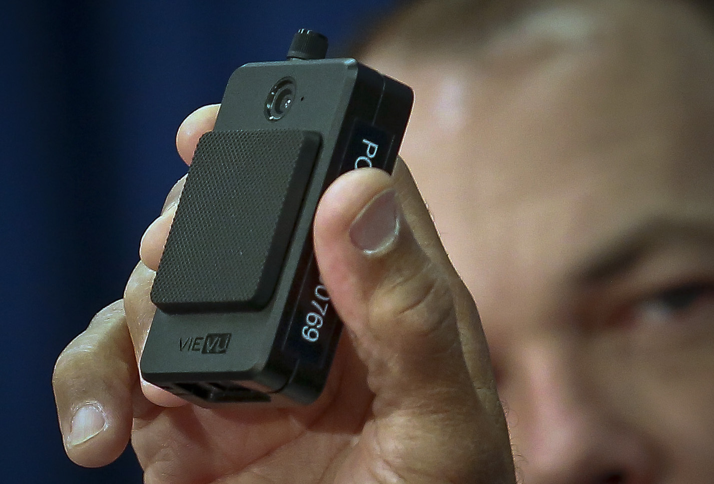A man holds up a body camera to be used by the NYPD.