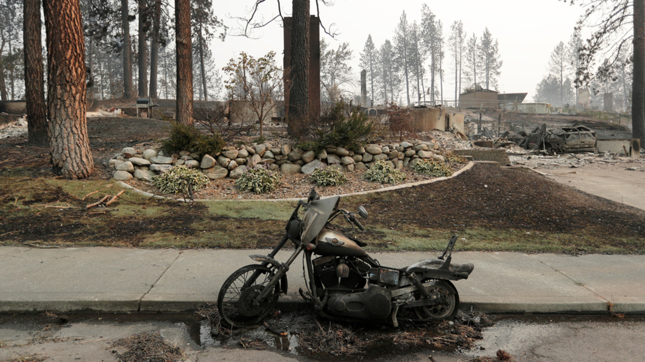 A burned motorcycle after a wildfire, Sunday, Aug. 2, 2026, in Spokane, Wash.