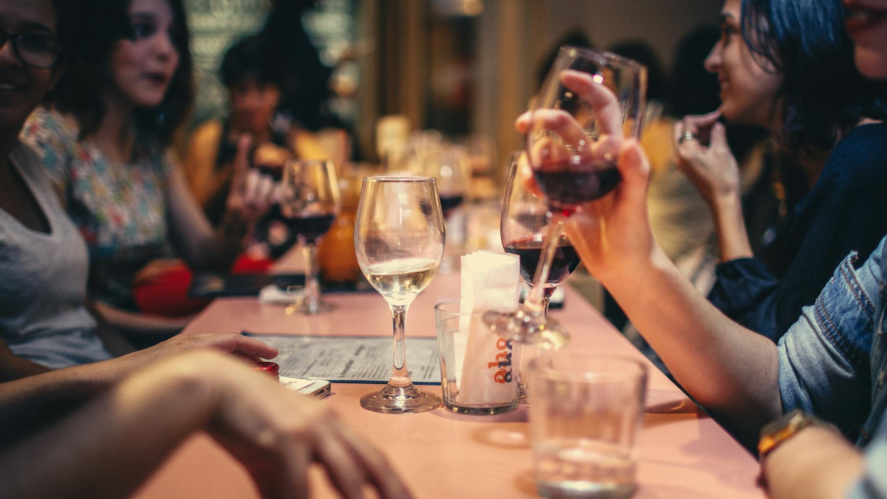 People Drinking Liquor and Talking on Dining Table Close-up Photo
